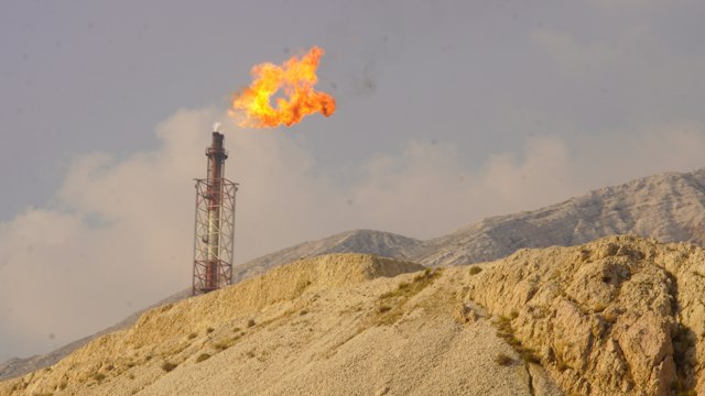 Gas flare burning at the top of a refinery flare stack