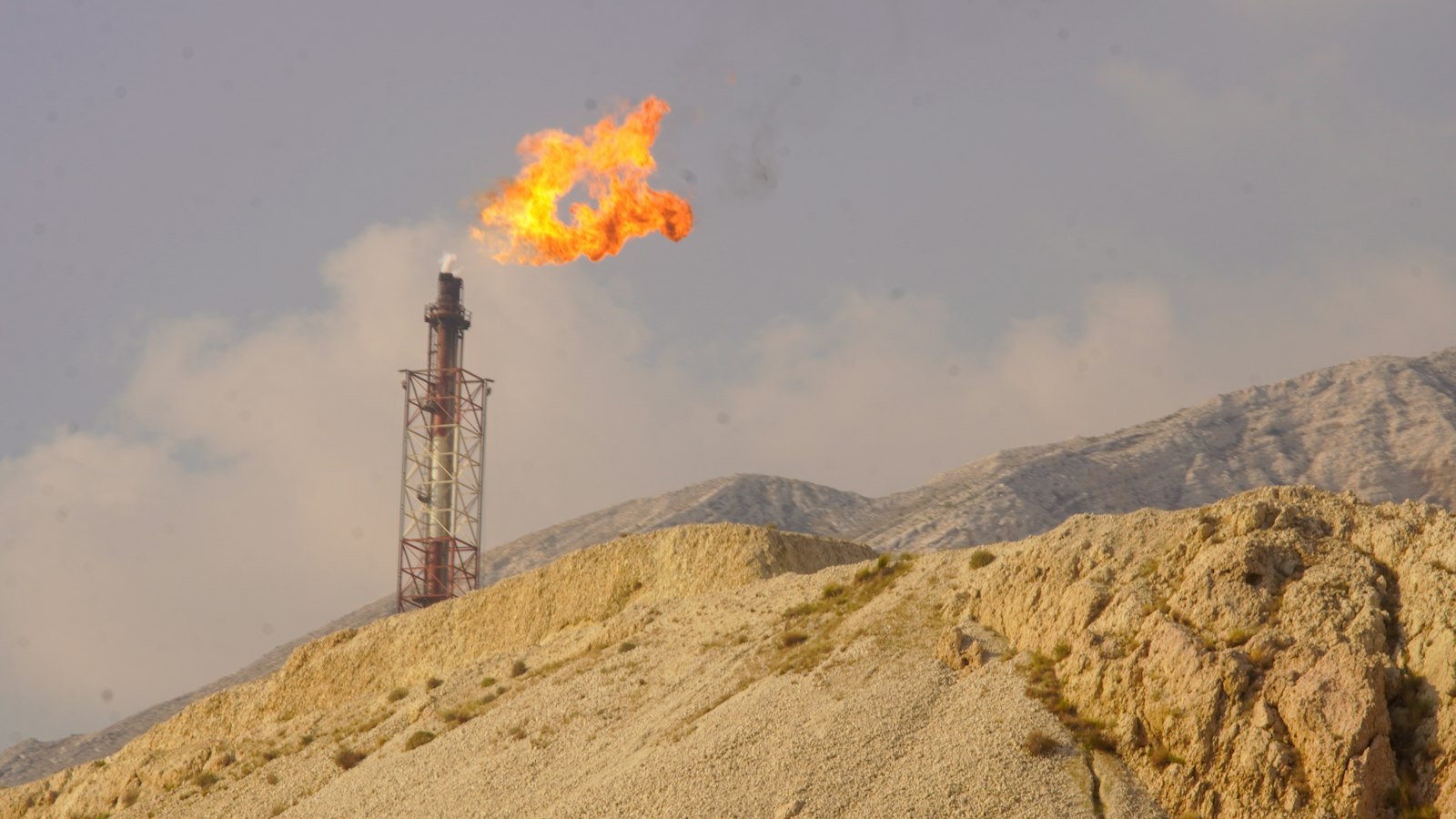 Gas flare burning at the top of a refinery flare stack