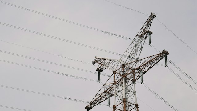 High-voltage transmission tower and conductors seen from below