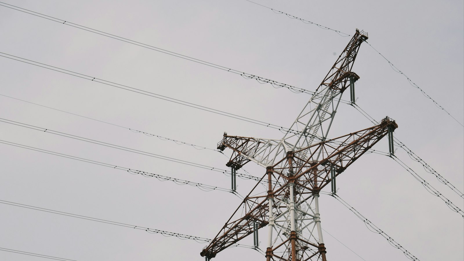 High-voltage transmission tower and conductors seen from below