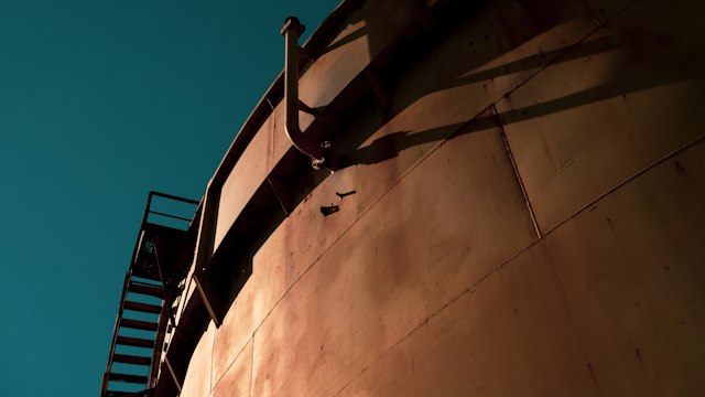 Large steel storage tank shell against a clear sky